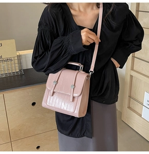 Detail of pink crocodile embossed handbag featuring silver double twist-lock closures