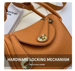 Gros plan du fermoir tournant doré sur sac à main en cuir grainé marron luxe