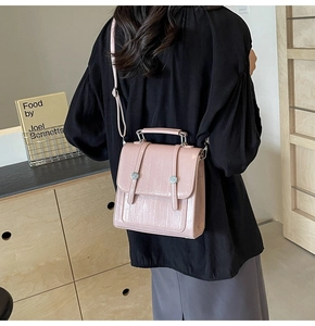 Close-up of pink textured leather backpack with metallic buckles and adjustable strap