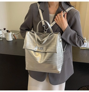 Silver metallic backpack with crinkled texture and oval metal twist-lock detail