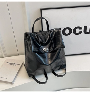 Detail of black textured PU leather backpack with silver metal twist lock closure