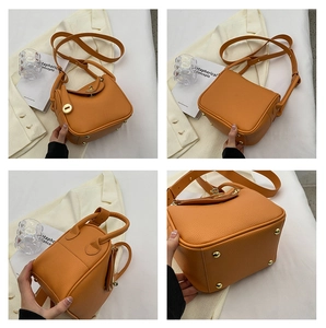 Vues détaillées du sac seau orange en cuir avec garniture dorée et pieds de protection
