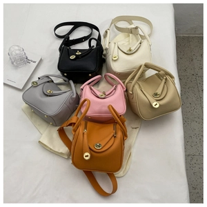 Sacs seau à motif litchi en six couleurs dont noir et beige sur tissu blanc
