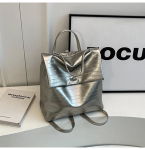 Detail of silver metallic backpack with horizontal texture and twist lock closure