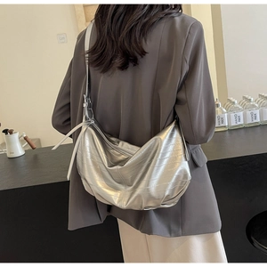 Silver crescent tote bag with horizontal embossed texture and metallic finish on shoulder
