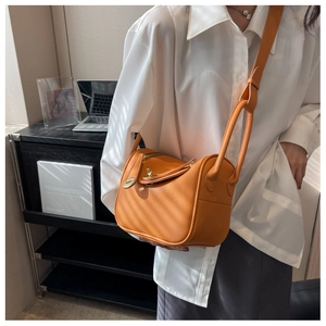 Détail d'un sac seau Lindy en cuir grainé orange avec bandoulière réglable pratique