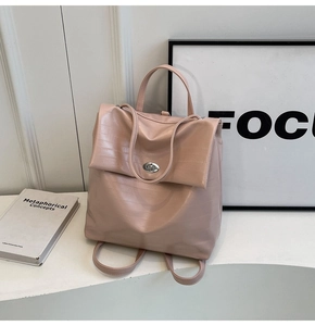 Detail of light pink faux crocodile leather backpack with metal twist lock closure