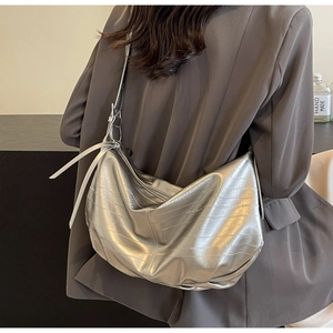 Detail of silver metallic crescent bag showing horizontal texture and slouchy drape style