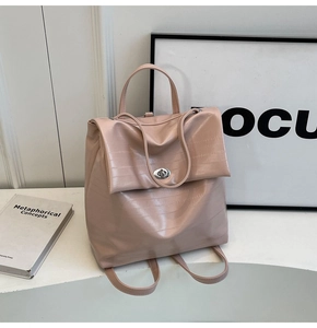 Detail of light pink crocodile embossed leather backpack with a silver twist lock closure
