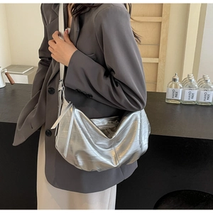 Detail of silver metallic tote with horizontal embossing and adjustable shoulder strap