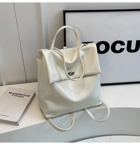 Detail of cream white faux crocodile leather backpack with silver turn-lock closure