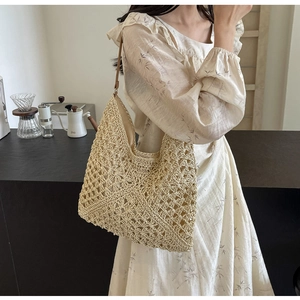Détail du sac seau en maille ajourée tissée main avec bandoulière brune au look épuré