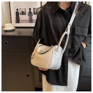 Détail du sac seau en cuir grainé gris avec fermoir métallique et bandoulière chic