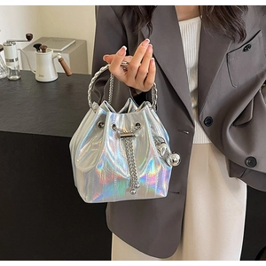 Detail of silver holographic bucket bag with metal chain strap and drawstring closure