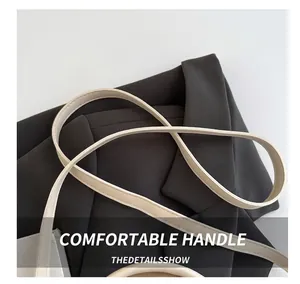 Detail showing the refined leather strap and high-quality fabric of this tote bag