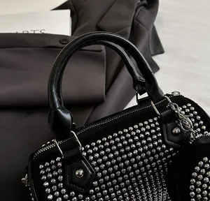 Detailansicht der schwarzen Zylindertasche mit silbernen Nieten und Leder-Tragegriffen