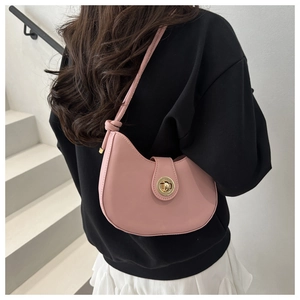 Chic pink crescent shoulder bag with golden knob lock and knot detail on black hoodie