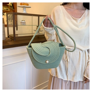 Détail du sac seau tissé vert menthe avec fermoir perle et texture en spirale