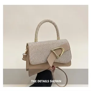 Close-up of beige crossbody bag with sparkling sequins and gold D-shaped buckle