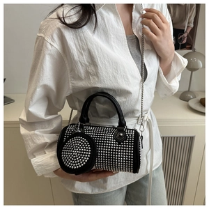 Détail du sac cylindre noir avec strass, bandoulière chaîne et mini porte-monnaie