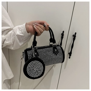 Detail der schwarzen Zylindertasche mit glitzernden Strasssteinen und silberner Kette