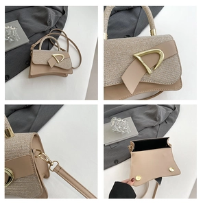 Detail of beige structured box bag with woven flap and gold D-shaped buckle