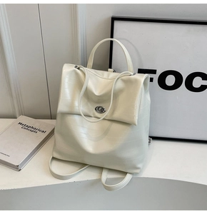Detail of off-white backpack featuring crocodile texture and silver metal twist lock