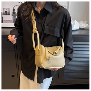 Détail du sac à main beige en cuir grainé avec fermoir rotatif et bandoulière large