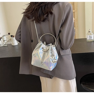 Detail of silver holographic bucket bag with ring handle and heart charm pendant