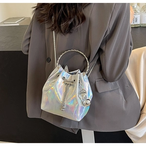 Detail of silver iridescent bucket bag with metal ring handles and heart charm