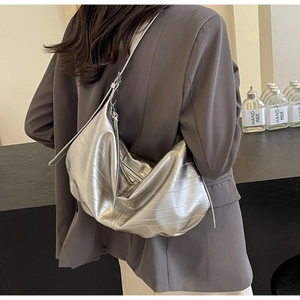 Detail of silver metallic hobo bag with wrinkled texture and zipper closure on shoulder