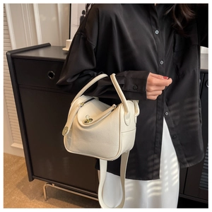 Détail du sac en cuir grainé blanc crème avec son fermoir pivotant en métal iconique
