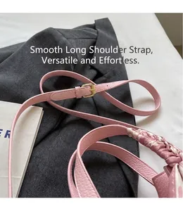 Detail of pink lychee leather handbag with silk scarf wrapped handle and gold buckle