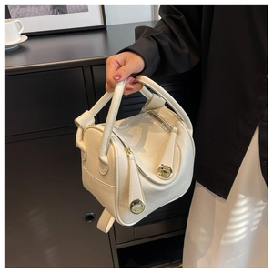 Détail du sac à main en cuir beige grainé avec fermoir en métal doré et fermeture
