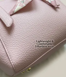 Detail of pink lychee grain leather with fine stitching and gold metal studs