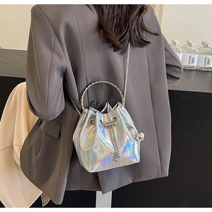 Detail of a mini bucket bag in silver laser leather with round metal handle and chain strap