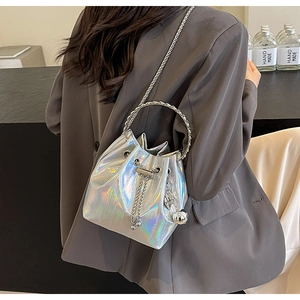 Detail of silver holographic bucket bag with ring handle and metal chain strap