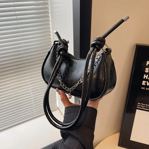 Fashionable black leather half-moon bag with pearl pendant and knotted shoulder strap
