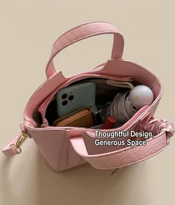 Spacious interior of pink pebbled leather bucket bag with daily items and silk scarf