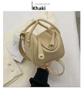 Détail du sac à main en cuir grainé kaki avec doubles poignées et fermoir pivotant