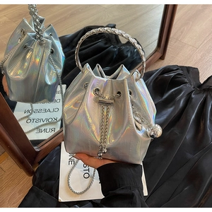 Detail of silver holographic bucket bag featuring rhinestone handle and metallic chain