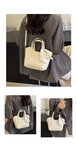 Detail of cream leather bucket bag with pebble texture and decorative silk scarf