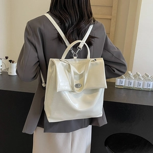 Chic cream crocodile pattern backpack with silver clasp shown on model in cafe setting
