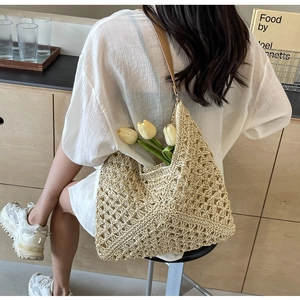Close-up of beige crochet bucket bag featuring lychee texture and leather straps