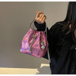 Detail of pink metallic bucket bag featuring silver round handle and heart charm