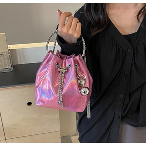 Detail of pink holographic bucket bag with metal ring handle and heart charm accents