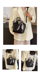 Close-up of black litchi pattern leather handbag with a stylish silk scarf handle detail