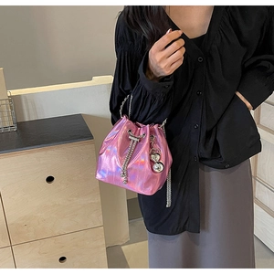 Detail of pink metallic drawstring bucket bag with silver chain and ball ornament