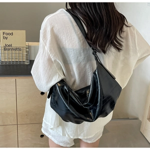 Detail of the black soft leather large capacity hobo bag showing adjustable strap and texture