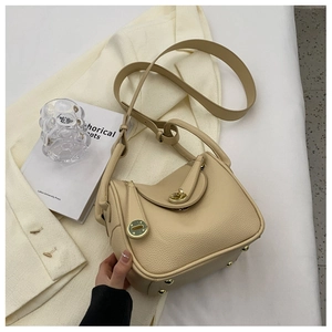 Détail du sac Lindy en cuir thé au lait avec fermoir doré et texture de cuir grainé